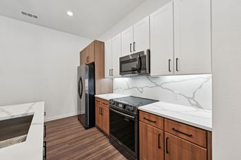 A kitchen with white countertops and wooden cabinets.